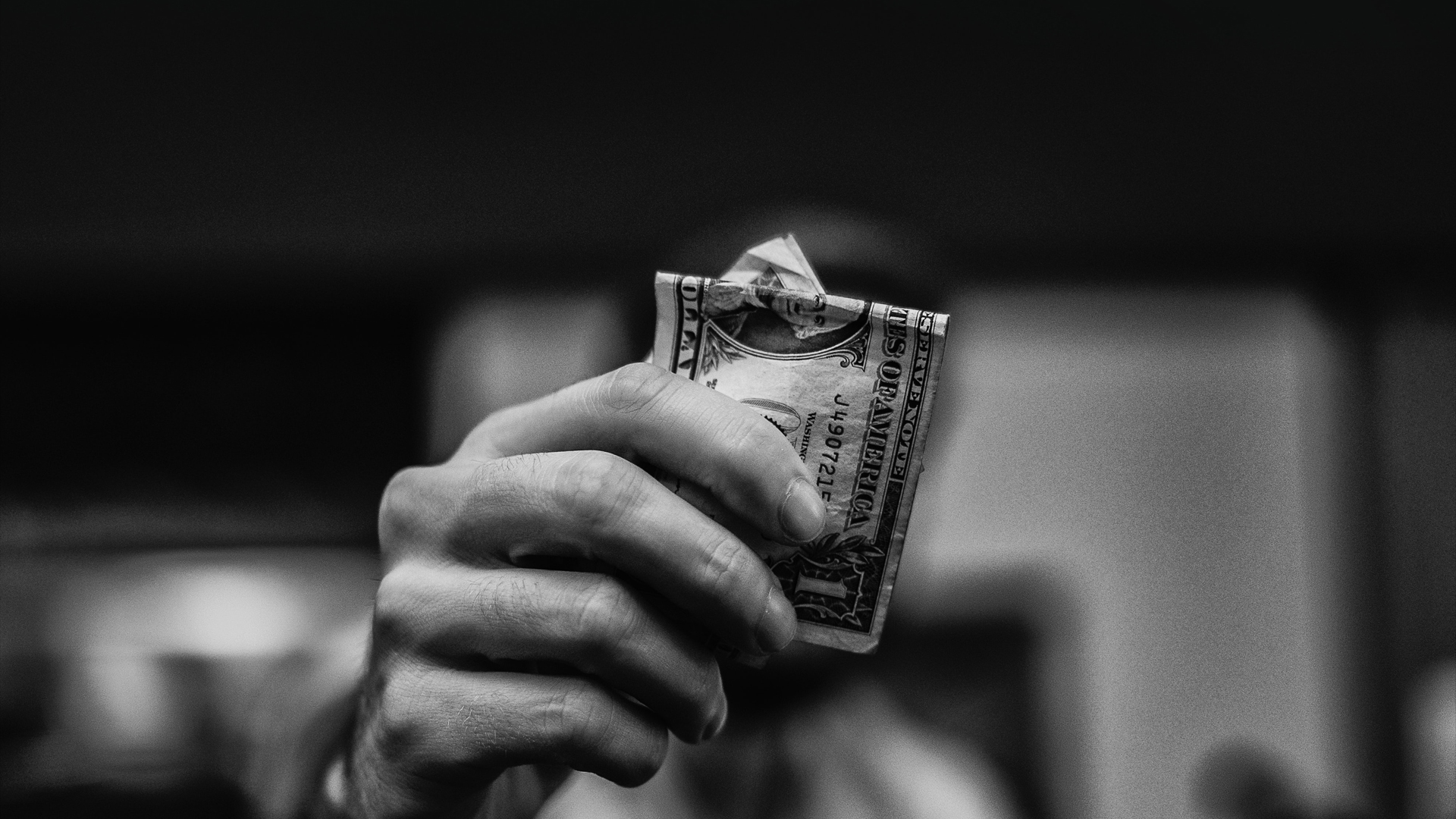 a hand holding a dollar